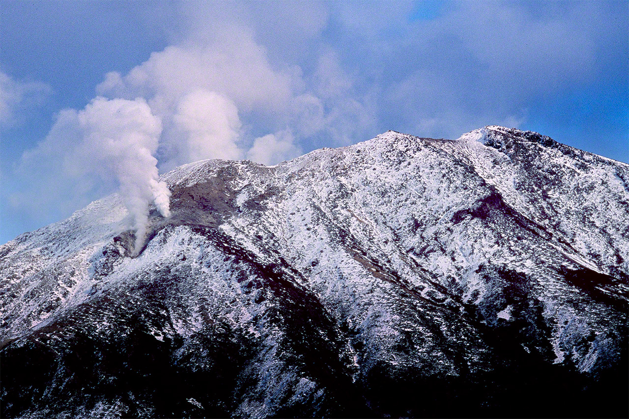 صورة لتصاعد الدخان من قمة ميكانداكي الذي يبلغ ارتفاعه 1499 متراً خلال فترات النشاط البركاني. (© ميزوكوشي تاكيشي)
