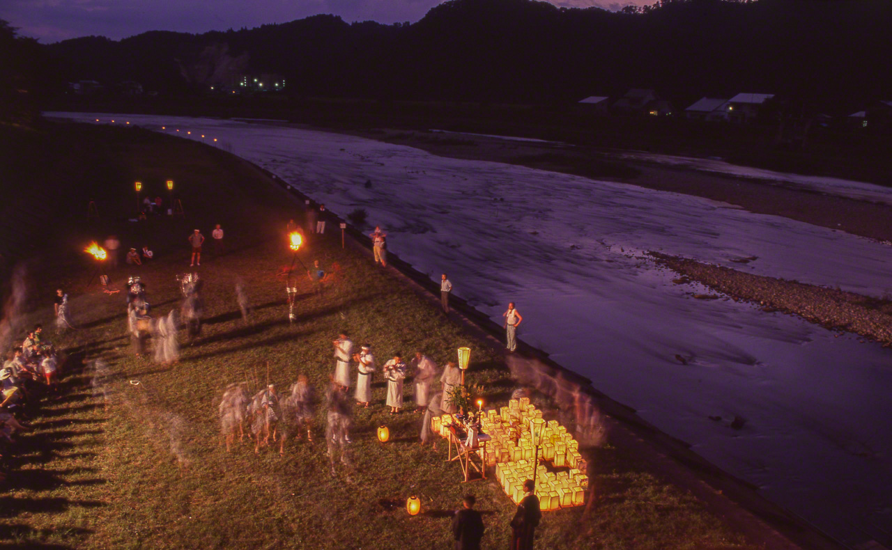 在流经秋田县角馆的桧木内川上放河灯。河灯照亮黑暗，引领祖先的灵魂顺流而下，渡过海洋平安抵达彼岸世界