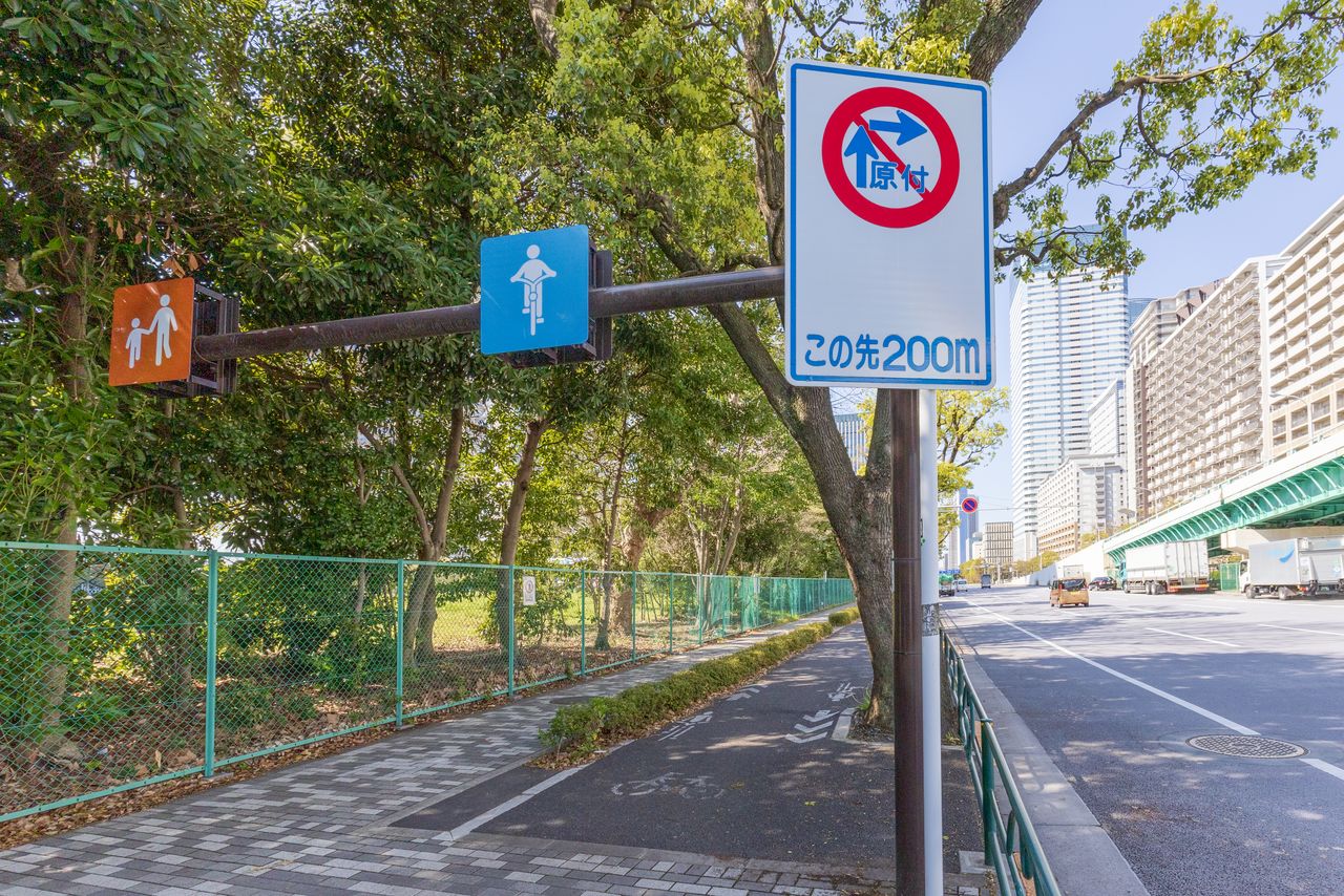 Signs indicate separate pedestrian and bicycle paths on some sidewalks along major thoroughfares. (© Nippon.com)