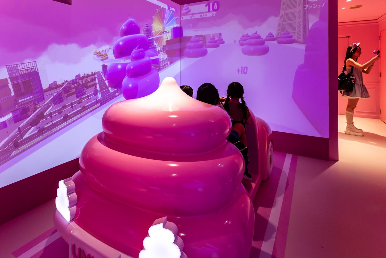 Race through the city using the steering wheel in “Go! Go! Poop Cart.” (© Nippon.com)
