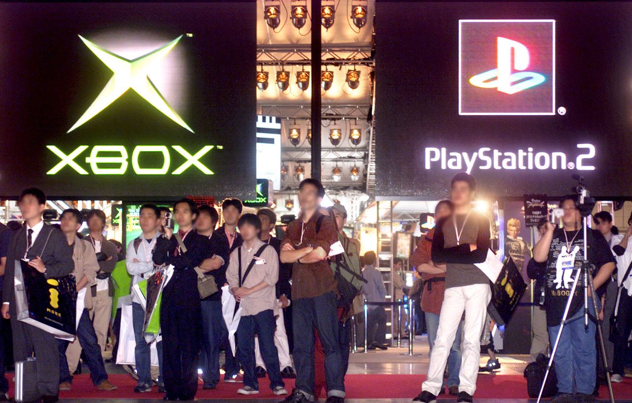 Visitors watch demonstrations of new Xbox and PS2 games at TGS 2001 Autumn. (© Reuters)