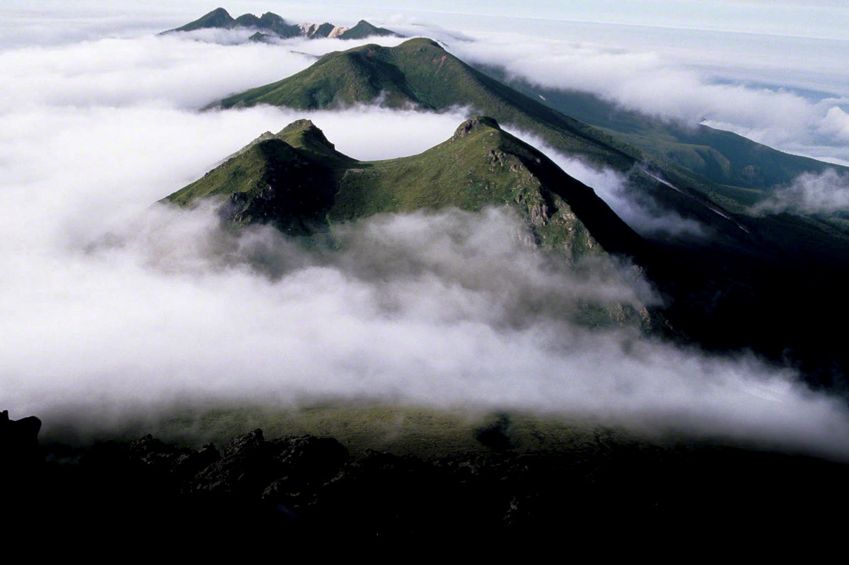 The mountains of the Shiretoko range peek through a sea of clouds. (© Mizukoshi Takeshi)