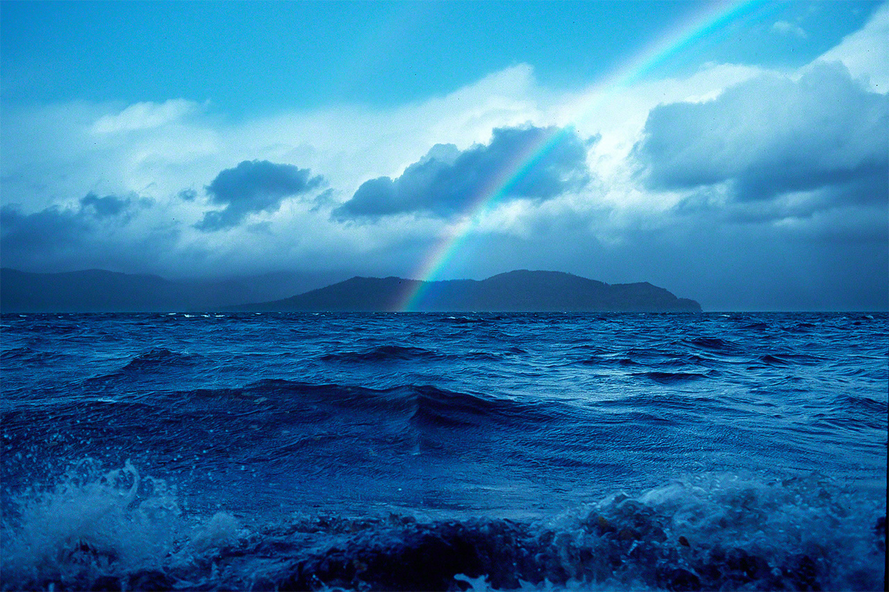 A rainbow appears over the choppy waters of Lake Kussharo following an evening squall brought by a cold front. (© Mizukoshi Takeshi)