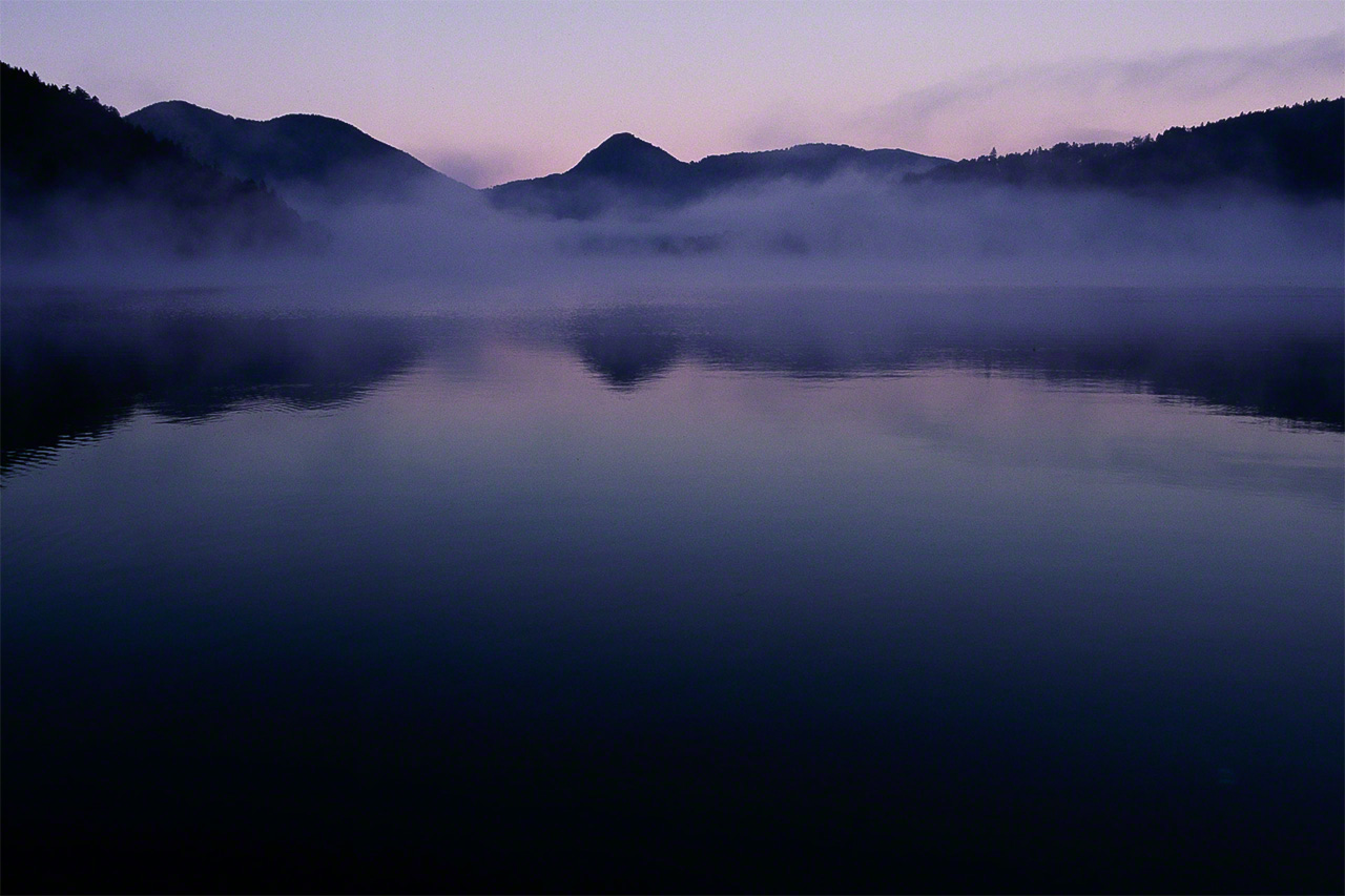 A dawn mist drifts over Lake Shikaribetsu in the Daisetsuzan National Park. Formed by a volcanic eruption damming the Shikaribetsu River, it is the highest lake in Hokkaidō, at 810 meters above sea level. (© Mizukoshi Takeshi)