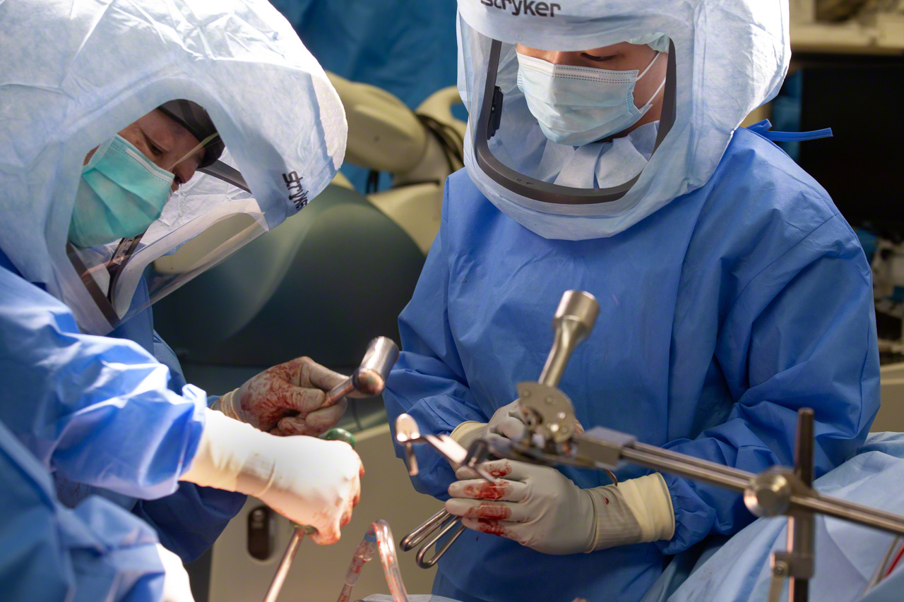 Dr. Matsubara uses a mallet and introducer to seat the artificial acetabular cup in the acetabulum. The surgeon can hear and feel the cup pop into place when the angle and depth of insertion are just right—a more reliable indicator than any electronic gauge. (© Ōnishi Naruaki)