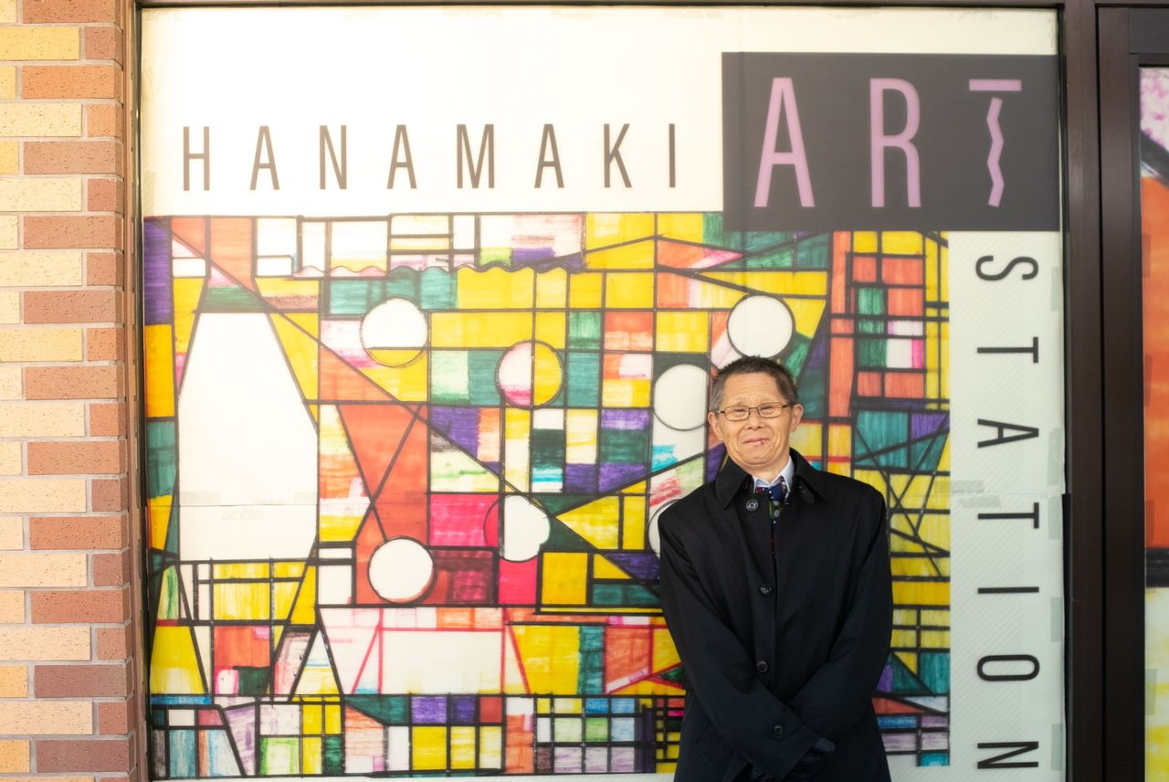 The late Yaegashi Kiyoshi in front of his artwork, used to wrap JR Hanamaki Station. (Courtesy Heralbony)