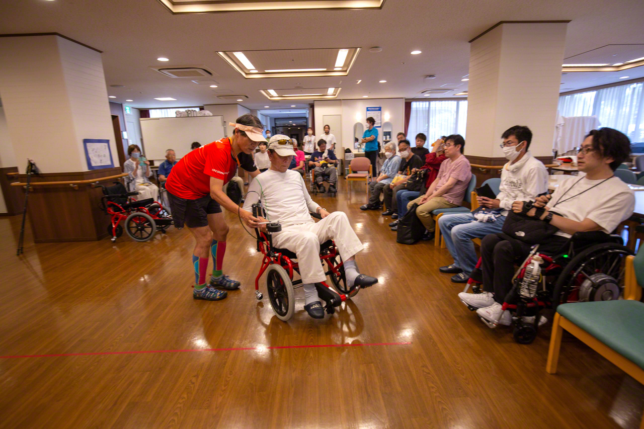 Uebayashi, who can “barely take one step,” successfully pedals a bright red Cogy at a test-driving event. (© Ōnishi Naruaki)