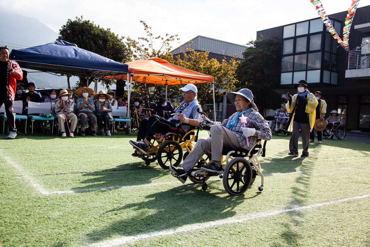 On Sports Day, patients compete in a Pedaling Olympics held on the grounds of the rehab center. Those pedal-powered chairs can really move! (© Ōnishi Naruaki)