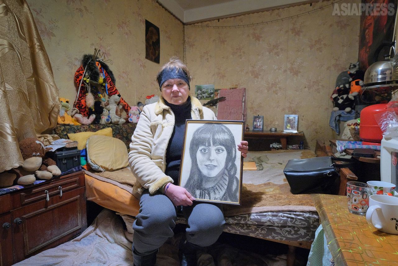 Olga holds a portrait of her late daughter, Katja. She says she had been excited to see the grandchild Katja had been about to deliver. (© Tamamoto Eiko)