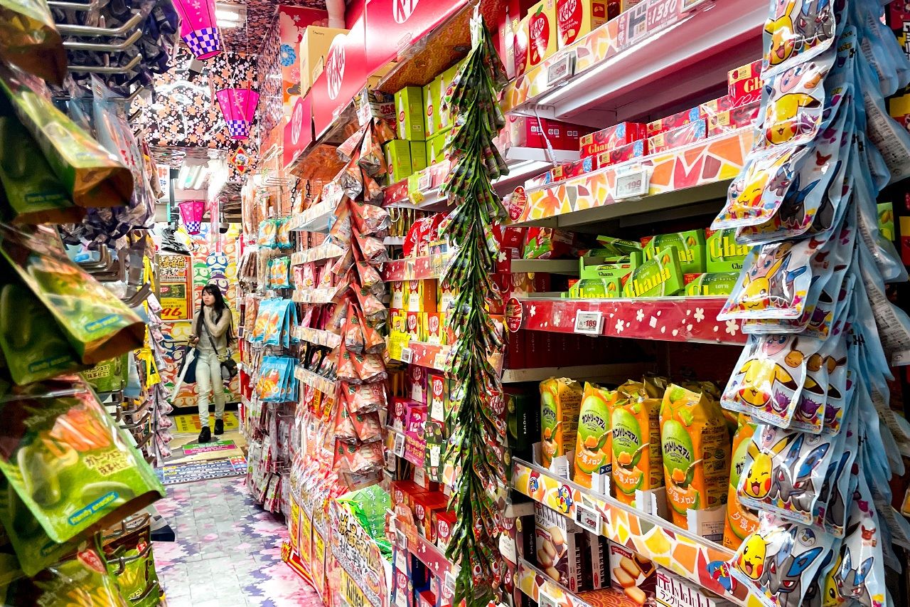 The snack section, with goods stacked nearly to the ceiling. The aisles are narrow, like a maze. Photo taken in Don Quijote Kabukichō on June 19, 2025. (© Tanigashira Kazuki)