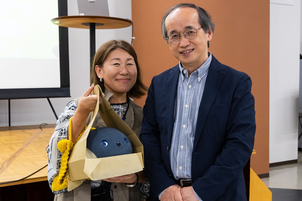Suzuki Fumiyo poses with Professor Okada, a proponent of “weak robots,” at the Nicobo fan meeting. (© Nippon.com)