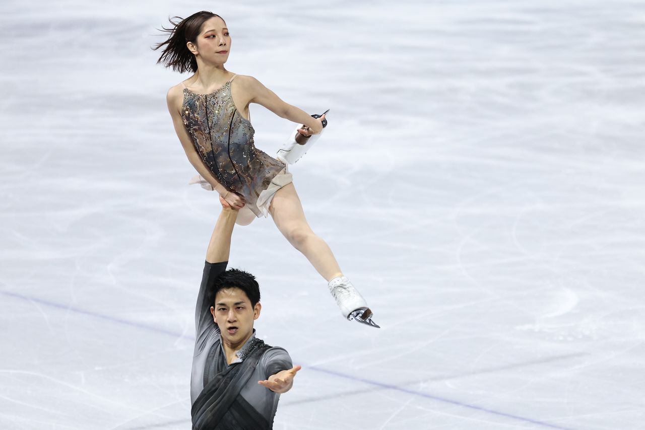 Kihara Ryūichi holds Miura Riku as they perform in the free skating section of the pairs figure skating event on February 17, 2026. (© Jiji)