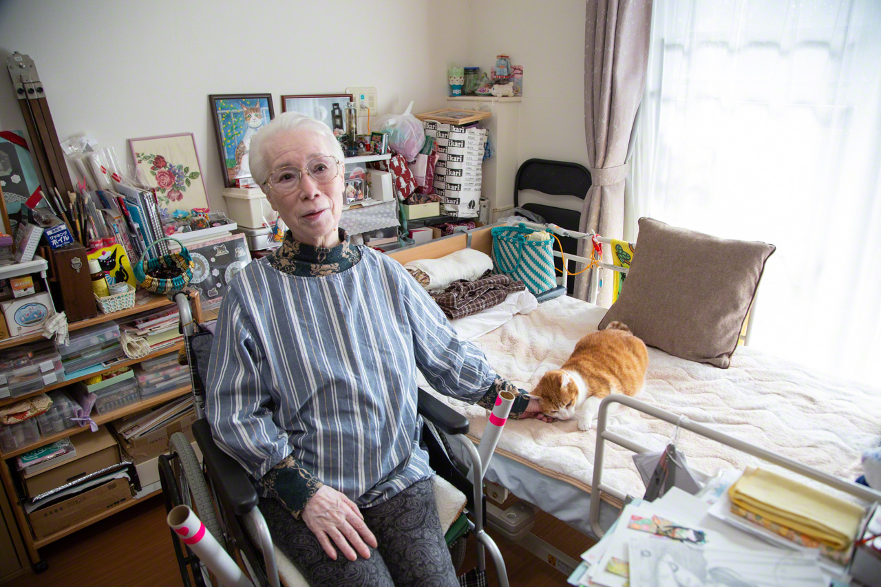 La señora Sawada, de 79 años, perdió al felino con el que ingresó en la residencia hace 3 años y ahora la gatita en acogida Yurikko viene a descansar con ella. El impecable gusto estético de la residente se nota en los cuadros y accesorios elaborados por ella misma que adornan la habitación.