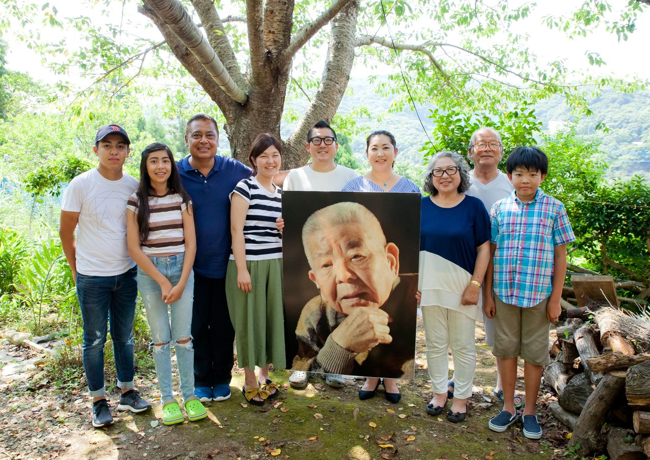 Photographie de Yamaguchi Tsutomu et de sa famille, exposée le 6 et 9 août 2017 à Hiroshima et Nagasaki respectivement. M. Yamaguchi a commencé à l'âge de 90 ans à participer à des activités où il racontait son expérience du bombardement atomique et de la souffrance et des horreurs qu’il a vécues. Il s'est éteint trois ans plus tard, en 2010. Voici le message de sa famille suite à son décès : « notre famille hibakusha hérite du souhait de notre grand-père et œuvre pour l'abolition des armes nucléaires et pour une paix durable dans le monde. »