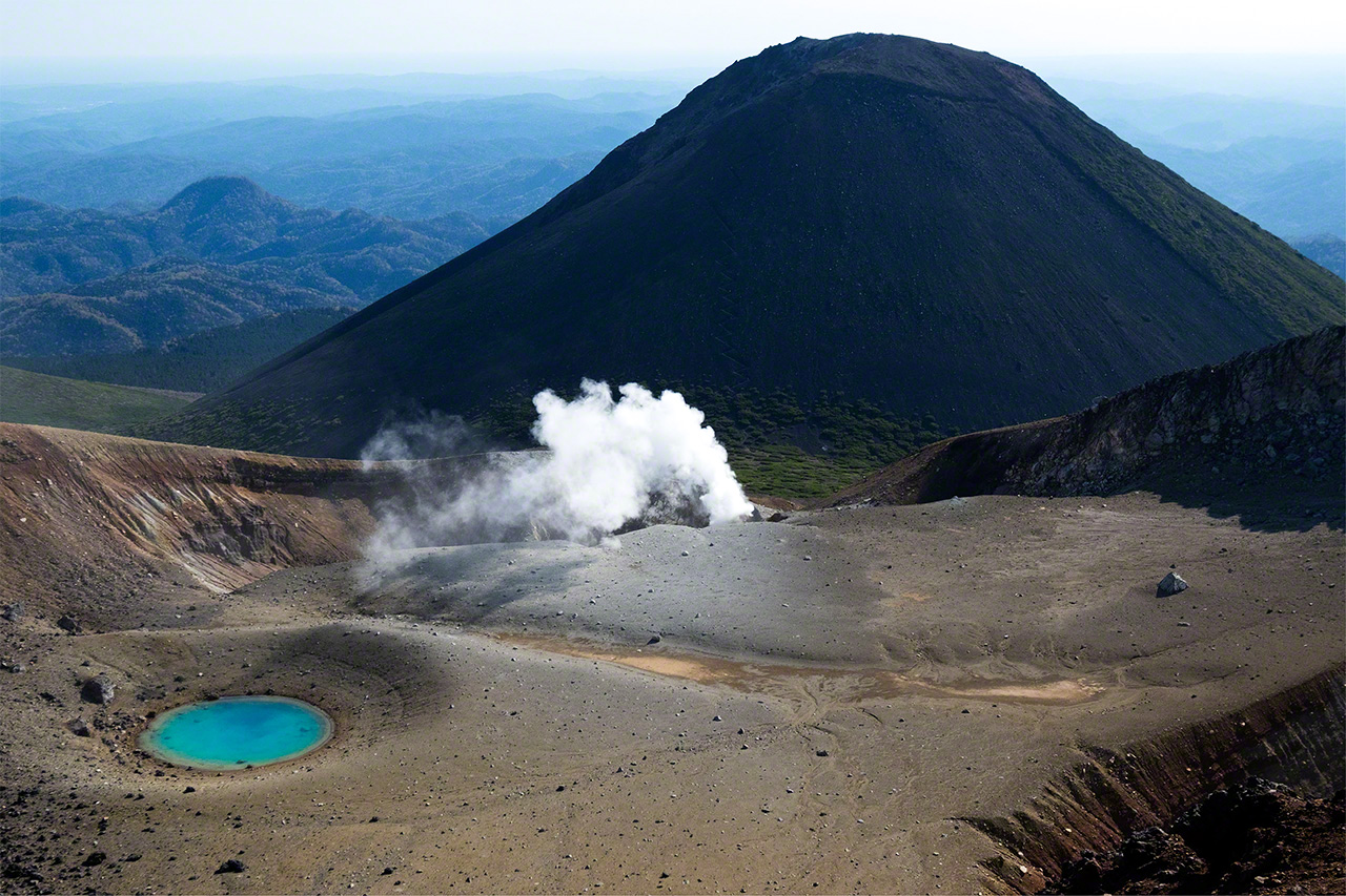 L'étang couleur vert émeraude Meakan,un volcan actif, avec le Fuji Akan (1 476 m) en arrière-plan.