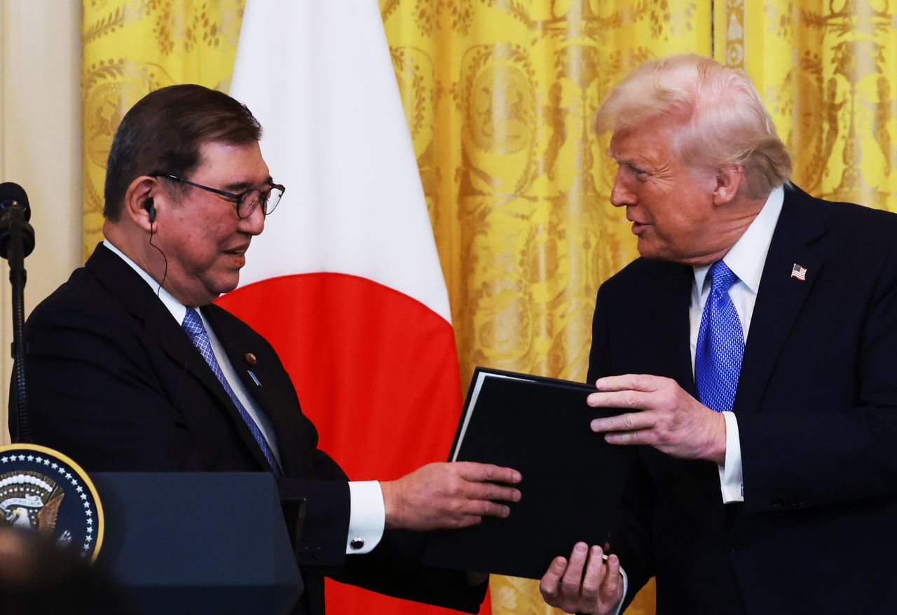 美日高峰會後的記者會上,美國總統川普(右)與日本首相石破茂共同展示紀念品,2025年4月7日,美國華盛頓(時事)