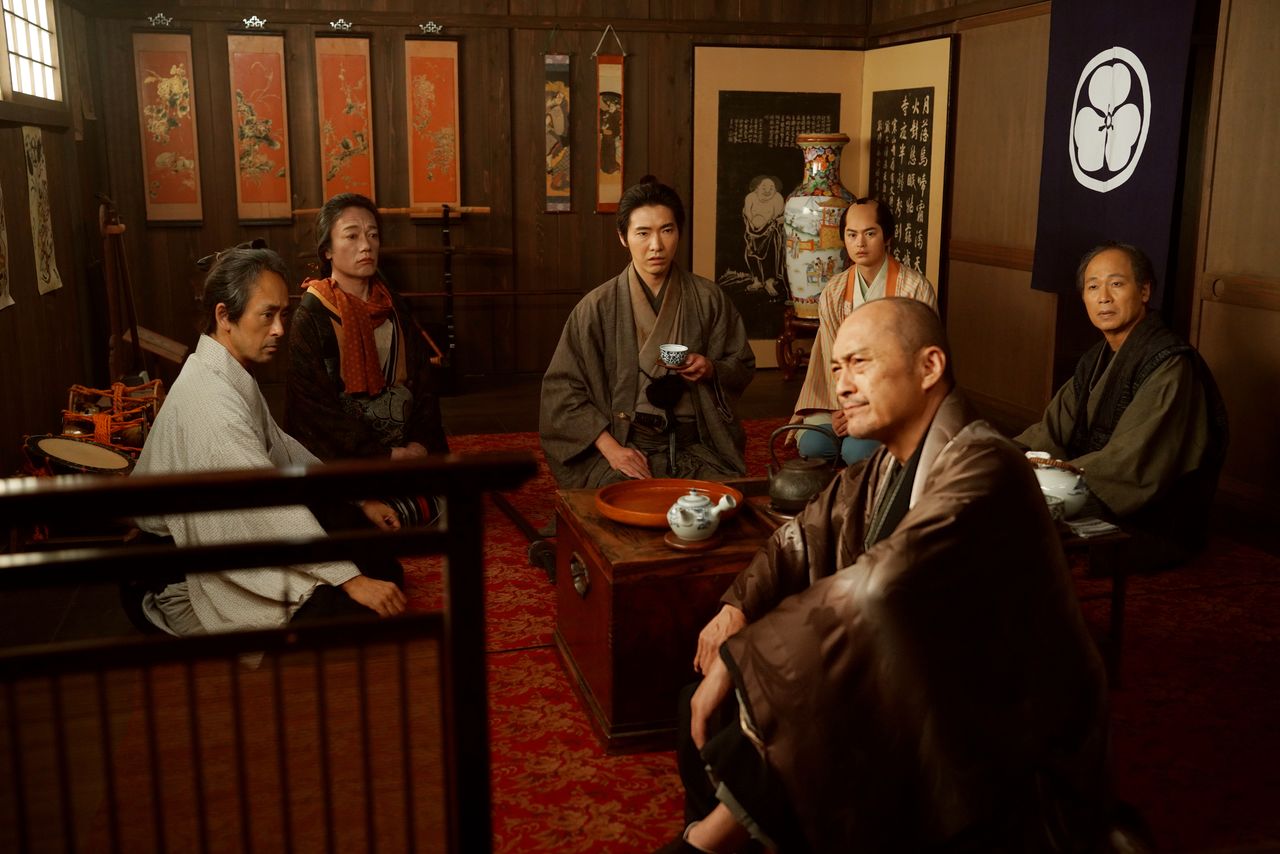 総一郎は立作者・篠田金治(渡辺謙、手前)ら森田座の面々の話をまとめ、仇討ちに隠された驚きの真相にたどりつく ©2026「木挽町のあだ討ち」製作委員会 ©2023 永井紗耶子/新潮社