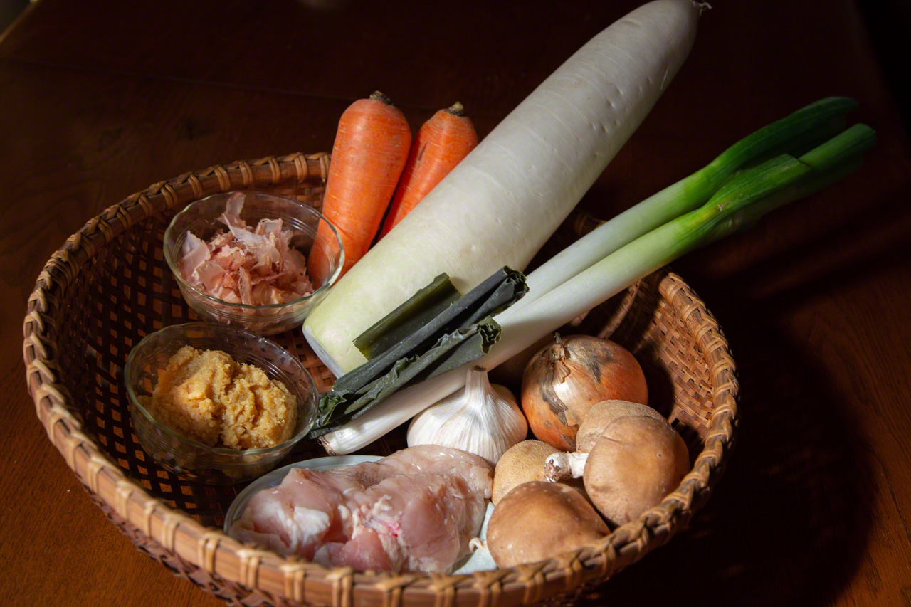 Ингредиенты хякусай набэ (по часовой стрелке начиная сверху): морковь, редис дайкон, комбу, лук-батун, чеснок, репчатый лук, грибы сиитакэ, курица, мисо и кацуо буси (хлопья ферментированного тунца бонито) (© Ониси Наруаки)